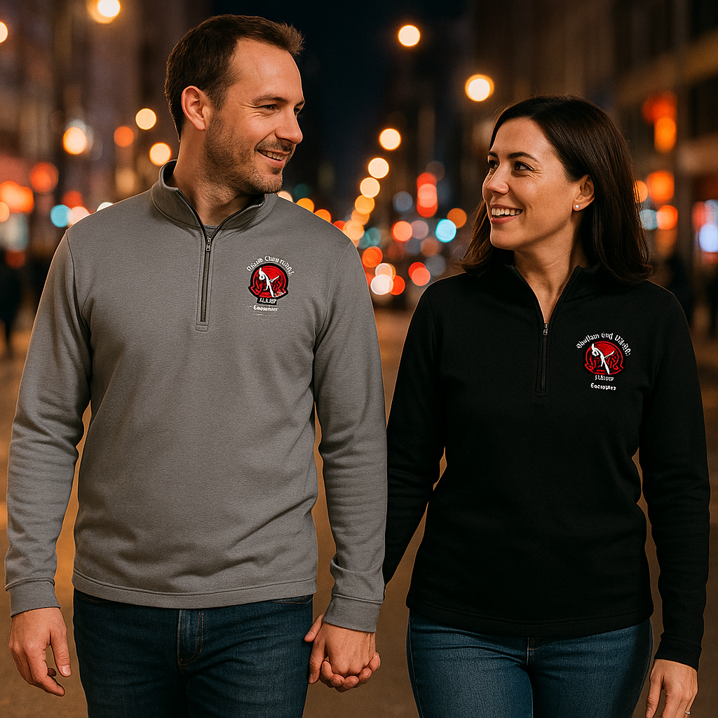Two people wearing branded pullovers with a blurred cityscape background